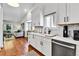 Modern kitchen with white cabinets, stainless steel appliances, and open view to living room at 11788 E Atlantic Pl, Aurora, CO 80014