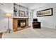Charming living room with a brick fireplace, built-in shelving, and a cozy armchair at 11788 E Atlantic Pl, Aurora, CO 80014