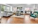 Well-lit living room boasts modern furnishings, hardwood floors, and large windows at 11788 E Atlantic Pl, Aurora, CO 80014