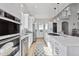 Modern kitchen featuring stainless steel appliances, white cabinets, and an island with cooktop at 12450 Watkins Rd, Hudson, CO 80642