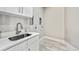 Functional laundry room with sleek countertop, stainless steel sink, and washer/dryer hookups at 12450 Watkins Rd, Hudson, CO 80642