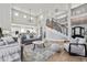 Elegant living room with an open floor plan and a modern curved staircase at 12450 Watkins Rd, Hudson, CO 80642