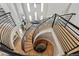 Dramatic view of the open staircase with iron railing leading to the bright living room at 12450 Watkins Rd, Hudson, CO 80642