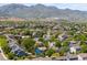Expansive aerial view showcasing a neighborhood, nearby pond, and rolling mountain landscape at 9569 Elk Mountain Cir, Littleton, CO 80125