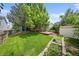 Expansive backyard featuring lush lawn, garden, mature trees, and deck at 9569 Elk Mountain Cir, Littleton, CO 80125