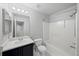 Bright bathroom with vanity, mirrors, and a shower-tub combo featuring clean, white tile at 9569 Elk Mountain Cir, Littleton, CO 80125