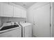 Laundry room with side-by-side Samsung washer and dryer and white cabinets at 9569 Elk Mountain Cir, Littleton, CO 80125