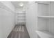 Bright walk-in closet features built-in shelving and ample storage space with gray carpeting at 9569 Elk Mountain Cir, Littleton, CO 80125