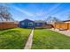 Blue house showcasing a well-maintained backyard, wooden deck, pathway, and wood fence at 1390 S Glencoe St, Denver, CO 80222