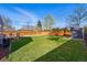 Spacious backyard with well-kept lawn, wood fence, deck, storage shed, and mature trees at 1390 S Glencoe St, Denver, CO 80222