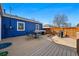 Exterior view of a blue home with a spacious deck featuring patio furniture and a grill at 1390 S Glencoe St, Denver, CO 80222