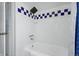Bathroom with white subway tiles with blue accents and a shower/tub combination at 1390 S Glencoe St, Denver, CO 80222