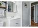 Clean bathroom features a white vanity, mirror, and view into hall at 1390 S Glencoe St, Denver, CO 80222