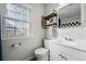 Bright bathroom with white vanity, toilet, decorative window, and stylish shelf at 1390 S Glencoe St, Denver, CO 80222