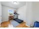 Bright bedroom featuring a treadmill, light hardwood floors, and a window providing natural light at 1390 S Glencoe St, Denver, CO 80222