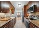 Efficient kitchen featuring wooden cabinets, tiled floors and stainless steel appliances at 1390 S Glencoe St, Denver, CO 80222