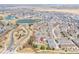 Aerial view of a community with a pond, green spaces, and residential houses at 17808 E 104Th Pl # C, Commerce City, CO 80022