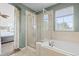 Primary bathroom with a glass shower enclosure, soaking tub, and a window for natural light at 17808 E 104Th Pl # C, Commerce City, CO 80022