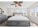 Carpeted primary bedroom with a ceiling fan, several windows, and a large bed with side tables at 17808 E 104Th Pl # C, Commerce City, CO 80022