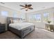 Primary bedroom with several windows and a ceiling fan with lighting overlooking the carpeted floors at 17808 E 104Th Pl # C, Commerce City, CO 80022
