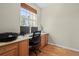Functional office space with built-in desk, hardwood floors, and a window providing natural light at 17808 E 104Th Pl # C, Commerce City, CO 80022