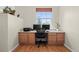 Bright office space with hardwood floors, built-in desk, and a large window offering natural light at 17808 E 104Th Pl # C, Commerce City, CO 80022