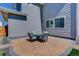 Back patio with brick and a small seating area with blue cushions creating an outdoor dining space at 14290 Hop Clover St, Parker, CO 80134