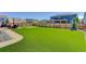 Fenced backyard with artificial grass, putting green, and outdoor dining area, great for entertaining and relaxation at 14290 Hop Clover St, Parker, CO 80134