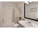 This bathroom features a shower over the tub, vanity sink, large mirror, and is well lit at 14290 Hop Clover St, Parker, CO 80134