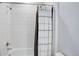 Stylish bathroom featuring white-tiled shower/tub with a striped white and brown shower curtain at 14290 Hop Clover St, Parker, CO 80134