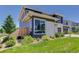 Well-maintained yard with lush green grass and manicured landscaping around the modern gray home at 14290 Hop Clover St, Parker, CO 80134