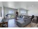 A modern living room features a large sectional couch, neighborhood views, and is well-lit by natural light at 14290 Hop Clover St, Parker, CO 80134