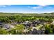Scenic aerial view of a residential neighborhood with lush green trees, rolling hills, and mountain views on the horizon at 3147 Juniper Ct, Golden, CO 80401