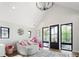 Well-lit bonus room includes a large seating area, a large modern light fixture and doors to the outdoor deck at 3147 Juniper Ct, Golden, CO 80401