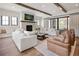 Bright living room with a stone fireplace, wood beams, and comfortable seating, perfect for relaxation and entertaining at 3147 Juniper Ct, Golden, CO 80401