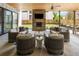Covered outdoor living space with stone fireplace, comfortable seating, and a view of the landscaped backyard at 3147 Juniper Ct, Golden, CO 80401