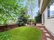 Lush backyard with mature trees, artificial grass, and a charming wooden deck for outdoor enjoyment at 2833 Open Sky Way, Castle Rock, CO 80109