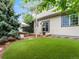 Beautiful backyard with a manicured lawn, mature trees, and an outdoor seating area at 2833 Open Sky Way, Castle Rock, CO 80109