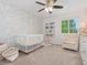 Cozy Bedroom featuring a crib, floral accent wall, and plenty of natural light at 2833 Open Sky Way, Castle Rock, CO 80109