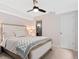Bedroom featuring a bed with an upholstered headboard, ceiling fan, and attached bath at 2833 Open Sky Way, Castle Rock, CO 80109