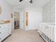 Bedroom view with floral accent wall, crib, closet with sliding doors, and a hall view at 2833 Open Sky Way, Castle Rock, CO 80109
