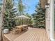 Spacious wooden deck with an outdoor dining set and shade umbrella, perfect for entertaining at 2833 Open Sky Way, Castle Rock, CO 80109