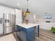 Open kitchen layout with a blue island, stainless steel appliances, and seamless connection to the living areas at 2833 Open Sky Way, Castle Rock, CO 80109