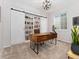 Modern office features a unique desk, built-in bookcase with sliding doors, and lots of natural light at 2833 Open Sky Way, Castle Rock, CO 80109