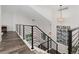Bright staircase with modern black railings, light wood floors, and decorative wall art on the landing at 2833 Open Sky Way, Castle Rock, CO 80109