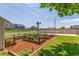 Lovely backyard with raised garden beds, windmill, and lush green grass at 606 Beth Ave, Fort Lupton, CO 80621