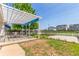 Spacious backyard featuring a pergola-covered patio, garden beds, and a white picket fence at 606 Beth Ave, Fort Lupton, CO 80621