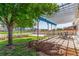 The backyard has mature trees, a pergola, a garden area, and a well maintained lawn at 606 Beth Ave, Fort Lupton, CO 80621