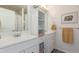 Bright bathroom featuring dual vanity sinks and a central storage cabinet with open shelving at 606 Beth Ave, Fort Lupton, CO 80621