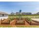 Picture of a garden area with raised beds and a charming windmill in the backyard at 606 Beth Ave, Fort Lupton, CO 80621